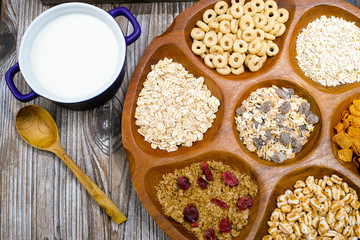 Wooden bowl with mixed breakfast cereals and blue bowl with fres