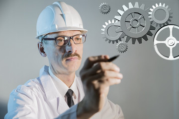 engineer designer scientist dressed in a construction helmet drawing