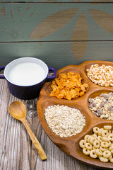Wooden bowl with mixed breakfast cereals and blue bowl with fres
