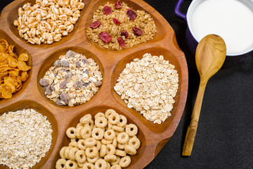 Wooden bowl with mixed breakfast cereals and blue bowl with fres