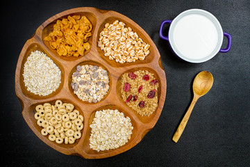 Wooden bowl with mixed breakfast cereals and blue bowl with fres