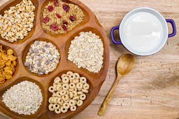 Wooden bowl with mixed breakfast cereals and blue bowl with fres