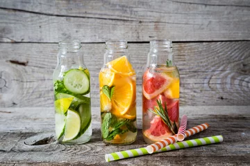  Selection of infused water in glass bottles, rustic wood background © anaumenko