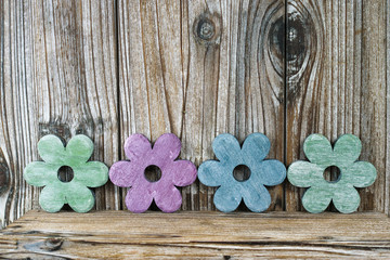Colorful wooden flowers on wooden background, decoration