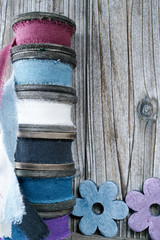 Colorful wooden reels with linen ribbons on wooden background