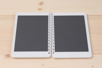 Two digital tablet devices connected with notebook spiral as a concept of opened digital notebook.   