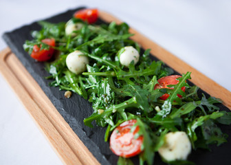 Fresh Italian salad with quail eggs, arugula and tomato with oli