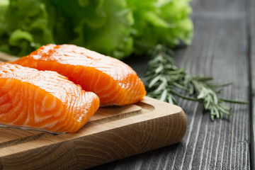Fresh raw salmon fillet on cutting board.