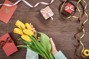 Mothers Day background. Tulips, gift boxes on wood