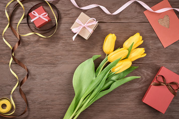 Mothers Day background. Tulips, gift boxes on wood