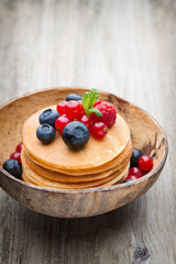 Stack of pancakes with blueberry and fresh berry.