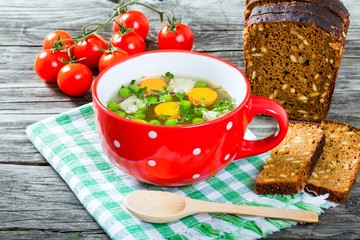 broth with vegetables, chicken meat and greens in the red soup c