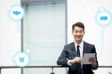 Young asian businessman using tablet, mobile phone in the office