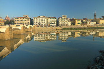 Fototapeta na wymiar Monumental buildings beautifully reflected in water of river Arno in Florence