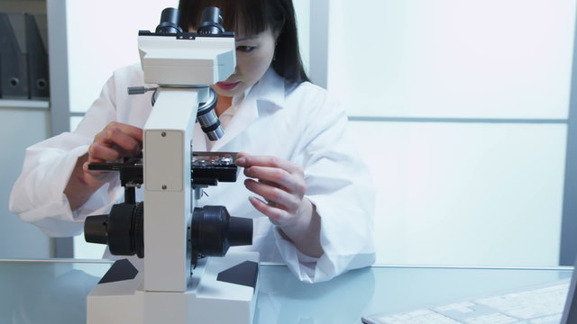 Scientist in lab working with microscope