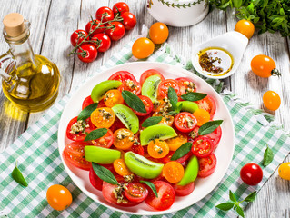 tomato, kiwifruit and mint salad with bottle of olive oil