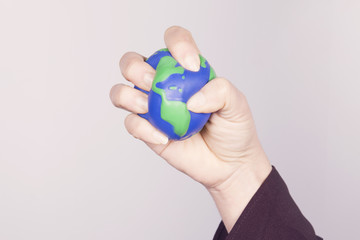 Hand compressing planet Earth. American continent.