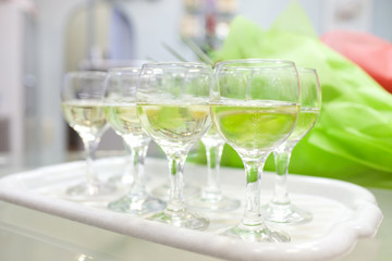 Glasses with mineral water on white tray