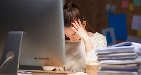 Young and beautiful businesswoman tired from work in the office