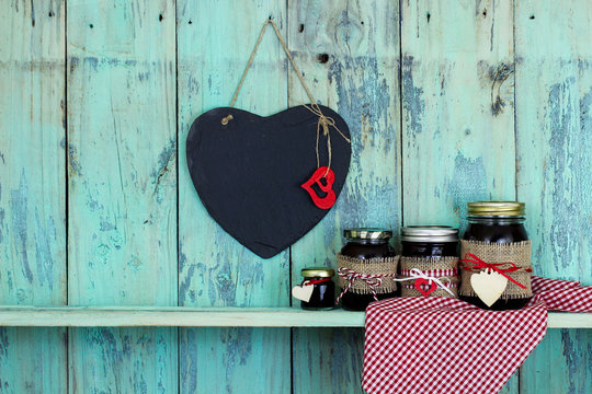 Blank slate heart hanging over jars of jam on shelf