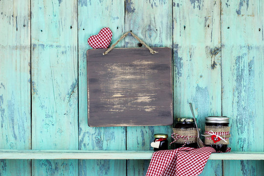 Blank wood sign with heart hanging over jars of fruit jelly
