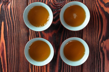 Obraz na płótnie Canvas Mug of hot delicious green tea on wooden background. Delicious oriental beverage.