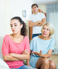 Relatives quarrelling with young woman in domestic interior