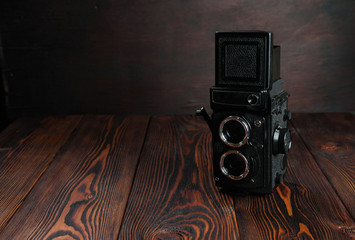 The old film camera on the wooden table.
