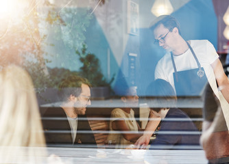 Couple being served by a waiter in busy cafe