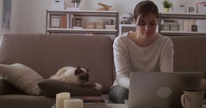 Woman cuddling her cat at home