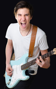 Teenage boy playing electric guitar and singing 