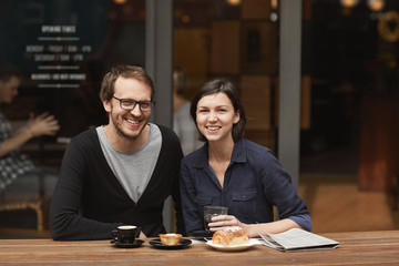 Smiling couple posing at modern outdoor cafe