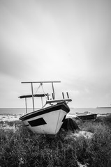 black and white image of fisherman boat on the beach.