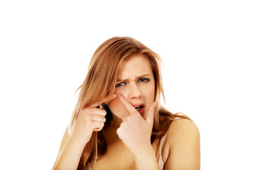 Teenage angry woman poping pimple