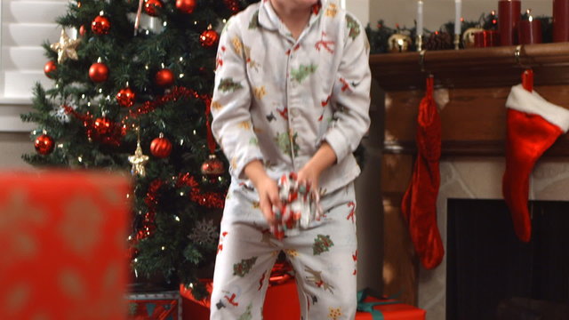 Young boy throws Christmas wrapping paper, slow motion