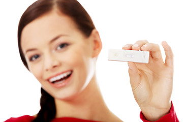 Happy young woman shows positive pregnancy test