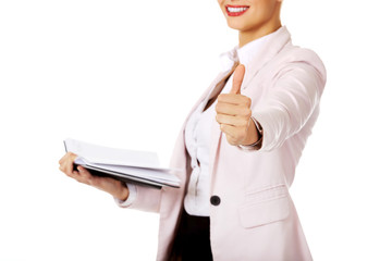 Smile business woman holding open notes and show thumb up