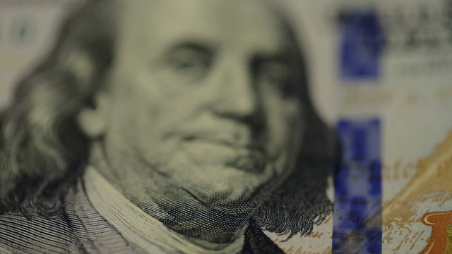Cash money background. Benjamin Franklin portrait on 100 US dollar bill close up, the image is rotated