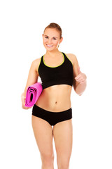 Woman ready for workout with yoga mats and thumb up