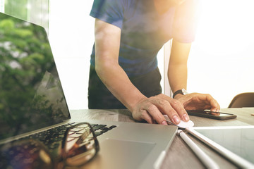 business man hand working on laptop computer on wooden desk as c