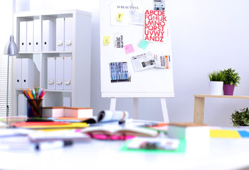 Desk of an artist with lots of stationery objects. Studio shot on wooden background