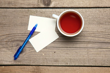 Blank business cards with pen and tea cup on wooden office table