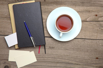 Blank business cards with pen, notebook and tea cup on wooden office table