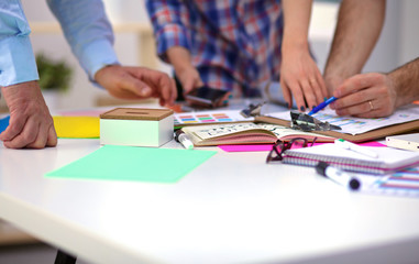 Close-up of three young creative designers working on project together. Team work