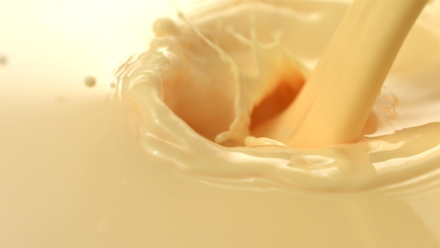Vanilla cream pouring and splashing, slow motion