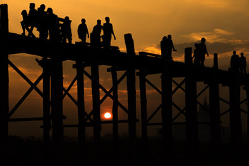 Silhouetted people crossing U bein bridge with sunset,The longes