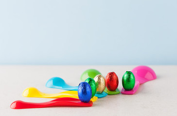 Chocolate Easter eggs wrapped in colorful foil placed on measuring cups. Shallow depth of field