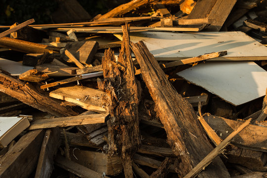 Holzbretter ungeordnet auf einem Haufen in verschiedenen Holzt&ouml;nen in der Abendsonne
