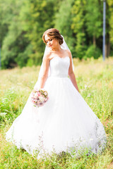 Beautiful bride with bouquet of flowers outdoor