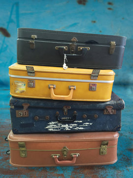 Stack of vintage suitcases on grungy rusty background